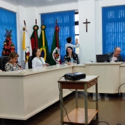 Imagem de pessoas sentadas em frente a bancada na Câmara de Vereadores